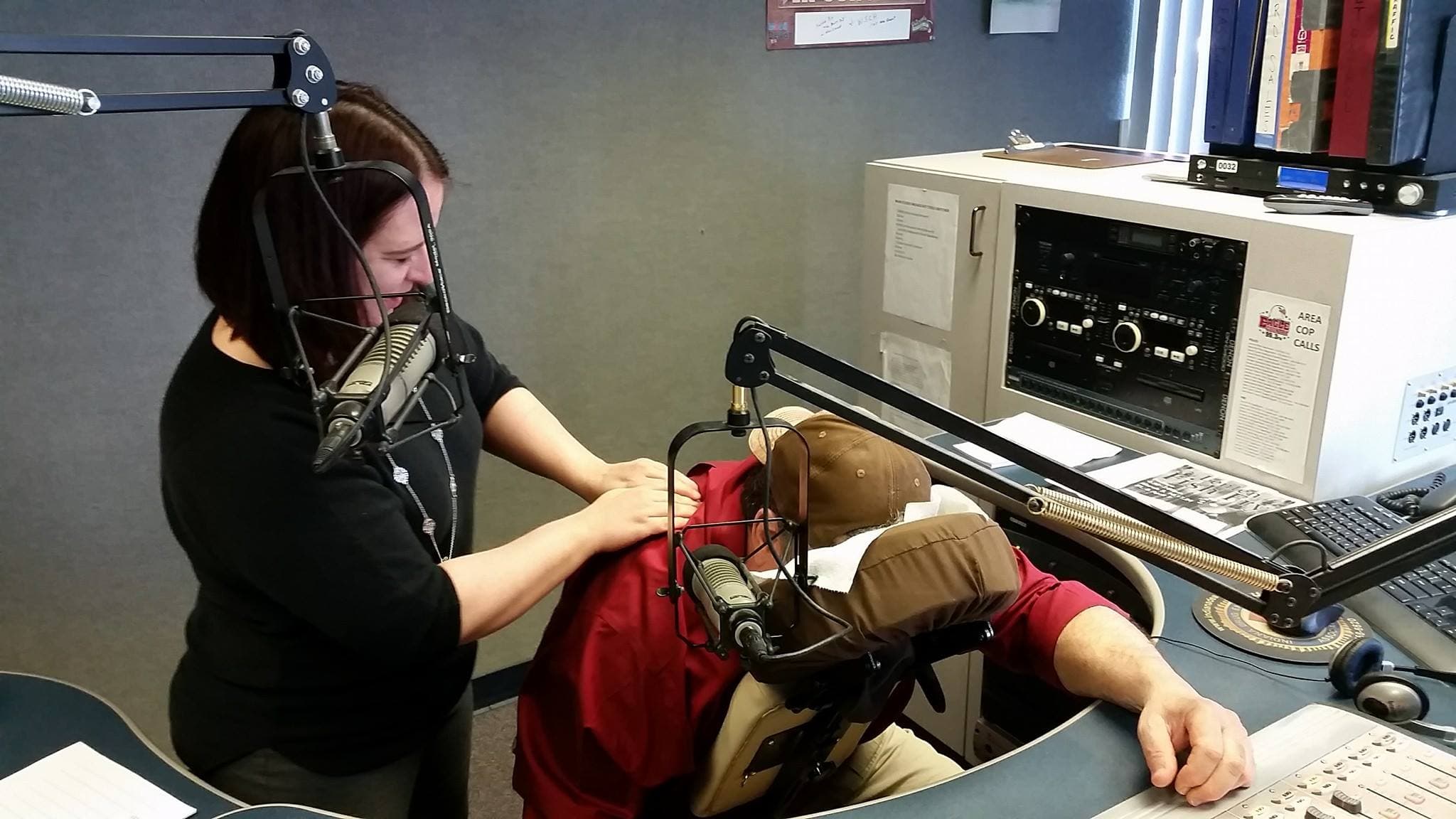 A Bliss Massage therapist giving an on-air neck and shoulder massage at a local radio station